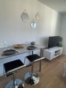 uma cozinha com uma mesa e dois bancos de bar em Studio cosy rue Alexander Taylor, Wifi, 2 pers em Pau