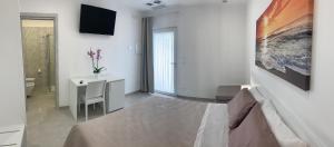 a bedroom with a bed and a desk and a television at Tenuta Verdolivo in Ostuni