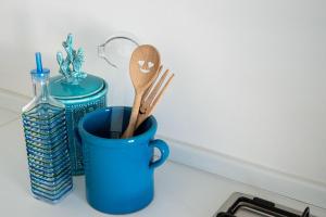 um copo azul com utensílios de madeira e uma garrafa de água em Dimora le Dune a 100 MT dal mare em Campomarino