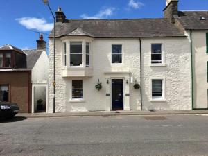 a white house on the side of a street at Seamore House in Moffat