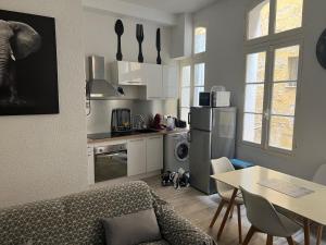 una cucina con divano e tavolo in una camera di Confort Appart a Béziers