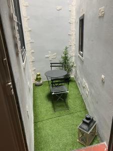 un piccolo cortile con tavolo e sedie su prato di Confort Appart a Béziers