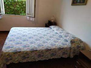 um quarto com uma cama com um cobertor azul em La Caletta Casa vacanza em La Caletta