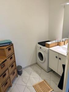 eine Küche mit einer Waschmaschine in der Ecke in der Unterkunft L’appartement du bonheur in Colombes