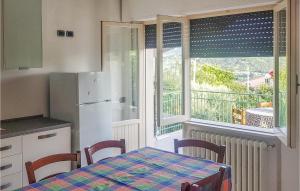 Montorio al VomanoにあるAmazing Home In Montorio Al Vomano With Kitchenのキッチン(テーブル、冷蔵庫付)、窓が備わります。