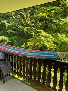 een hangmat op een balkon met uitzicht op de bomen bij Loge des rêveurs in Les Carroz d'Araches
