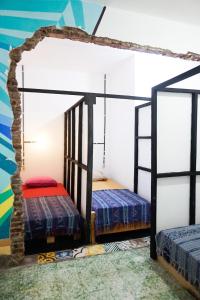 two beds in a room with a mural at Good Karma Yogyakarta in Yogyakarta
