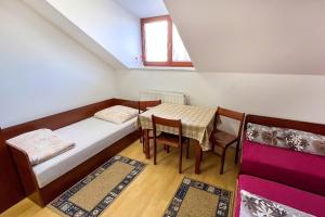 a small room with a bed and a table and chairs at Penzion Navara in Kolín