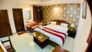 Habitación de hotel con cama y sofá en Kashish Residency and Banquet, en Noida