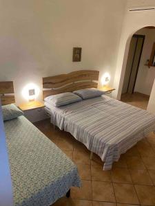 1 Schlafzimmer mit 2 Betten und 2 Tischen mit Lampen in der Unterkunft Sonia’s sea house in San Pietro in Bevagna