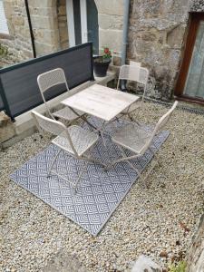 2 Stühle und ein Tisch auf der Terrasse in der Unterkunft JOLIE MAISON DE VILLAGE in Mégrit