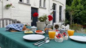 a table with plates of food on a green table cloth at Bed & Breakfast By Genck in Oudenbosch