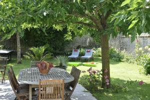 einen Tisch und Stühle unter einem Baum im Garten in der Unterkunft Studio du Puits sainte Claire in Courçon