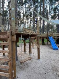 a wooden playground with a slide and a swing at Villa Marika Holiday Centre in Alajõe +48 photos