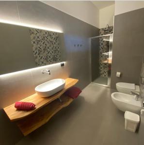 ein Badezimmer mit einem Waschbecken, einem WC und einem Spiegel in der Unterkunft Sonia’s sea house in San Pietro in Bevagna