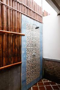 y baño con ducha y pared de azulejos. en Good Karma Yogyakarta, en Yogyakarta