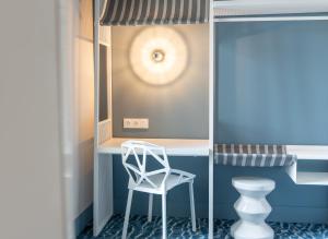 La salle de bains est pourvue d'une chaise blanche et d'un bureau. dans l'établissement Ibis Styles Le Touquet, à Le Touquet-Paris-Plage