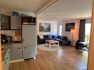 een keuken en een woonkamer met een bank en een tafel bij BEEKBERGEN staying in the WOODS freestanding chalet WASMACHINE ALL COUNTRY TV CHANNELS EXPATS WELCOME in Beekbergen