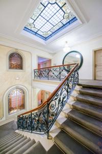 an ornate staircase in a building with a skylight at Hôtel Régent Contades in Strasbourg