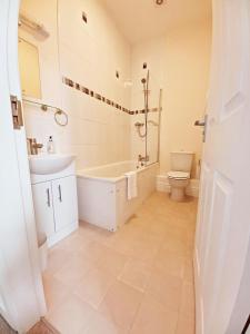 y baño con bañera, lavabo y aseo. en Serendipity cottage, en Castleton