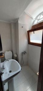 a bathroom with a white sink and a window at Petrino Vessa in Véssa