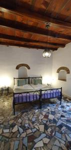 uma cama num quarto com piso de pedra em Petrino Vessa em Véssa