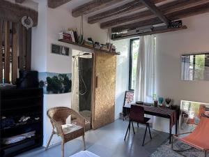 ein Wohnzimmer mit einem Schreibtisch und einem Spiegel in der Unterkunft Maison au bord de l’eau in Annay-sur-Serein