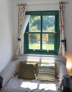 a window in a room with a couch in front of it at The Owl Box: self-contained private annex & garden in Horseheath