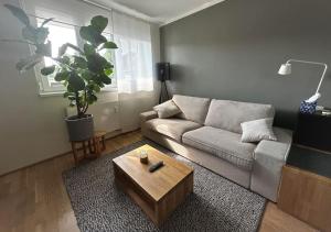 uma sala de estar com um sofá e uma mesa de centro em Trendy Getaway em Ljubljana