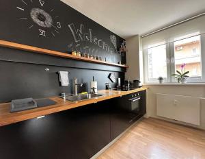 a kitchen with a sink and a black wall at Trendy Getaway in Ljubljana