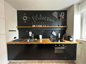 a kitchen with a sink and a black wall at Trendy Getaway in Ljubljana