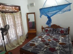 a bedroom with a bed and a mirror at Rosa Kusum Vacation Home Near Kudawa Beach In Kalpitiya in Kalpitiya