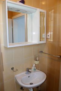 La salle de bains est pourvue d'un lavabo et d'un miroir. dans l'établissement Bjelopera Rooms, à Zaton