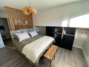 克莱蒙费朗Appart T2 avec parking, loggia, vue Puy de Dôme的卧室里有一张床和一把椅子