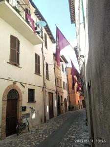 un callejón con banderas y una bicicleta en una calle en Casa Marianna - Centro storico, en Foligno
