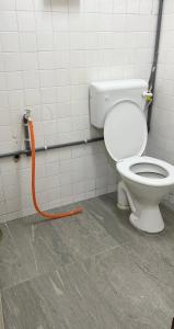 een badkamer met een toilet met een oranje slang bij CikSiti homestay02 in Kajang