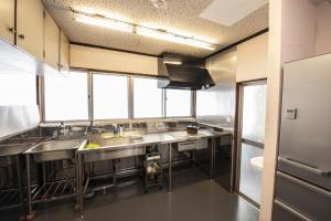 a large kitchen with stainless steel counters and windows at Oto Iro Riva HOUSE - Vacation STAY 18694v in Kure