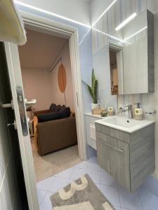 uma cozinha com um lavatório e uma sala de estar com um sofá em cozy minimal apartment em Piraeus
