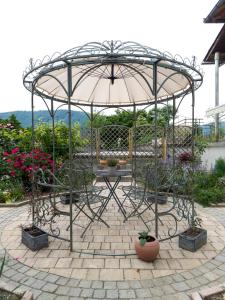 une terrasse avec un parasol et des plantes en pot dans l'établissement Hiša Magnolija, à Tolmin