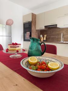 Hiša Magnolija في تولمين: صحن فاكهة على طاولة مع مزهرية
