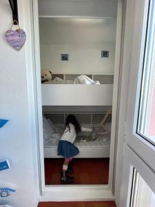una niñita parada en un estante en una habitación en Studio cabine à barcares, en Le Barcarès