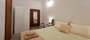 a bedroom with a large white bed and a mirror at House on Sea Sifnos in Cherronisos