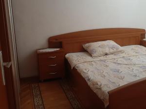 a small bedroom with a bed and a night stand at Apartments Kalsan in Novalja