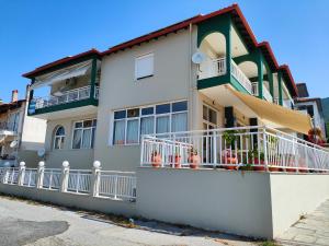 a white and green building with balconies at PhiloxenInn in Polygryos