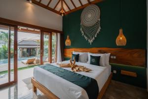 a bedroom with a bed with two animals on it at EHOA BALI Nyanyi Boutique Hotel - In front of entrance to NUANU in Tanah Lot