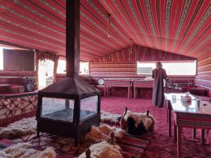 a room with a stove in the middle of a room at Wadi Rum Desert Heart Camp in Wadi Rum