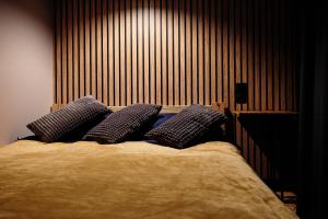 a bed with three pillows on top of it at Apartament Incognito Rynek in Tarnobrzeg