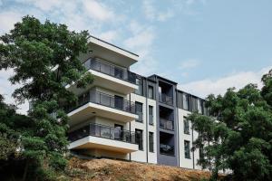 an apartment building on top of a hill with trees at Apartament Incognito Rynek in Tarnobrzeg