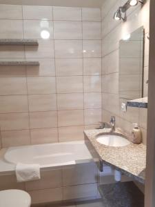 ein Badezimmer mit einer Badewanne, einem Waschbecken und einem WC in der Unterkunft Apartamenty Rodzinne Pilica PARK in Sulejów