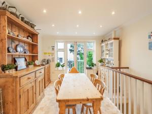 a kitchen with a wooden table and chairs in a room at The Cottage in St Margarets at Cliff